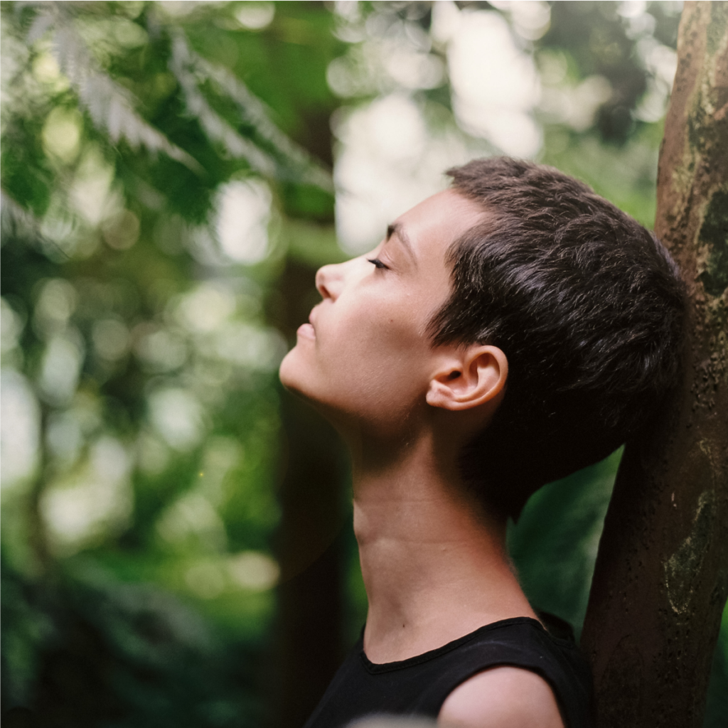 femme méditant contre un arbre