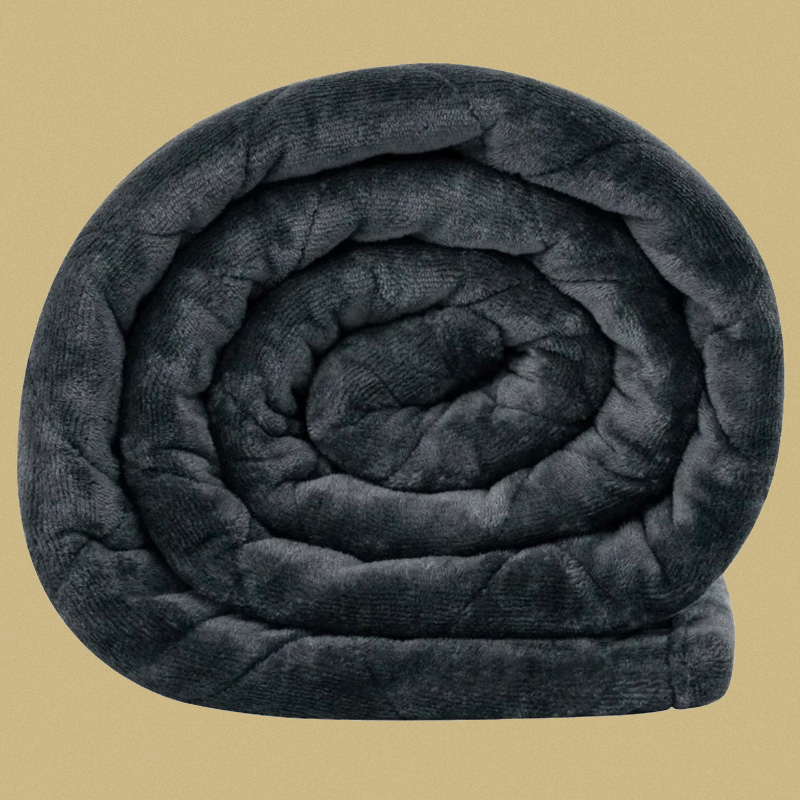 Couverture lestée enroulée favorisant la relaxation profonde et l’intégration après une séance de shiatsu ou de réflexologie